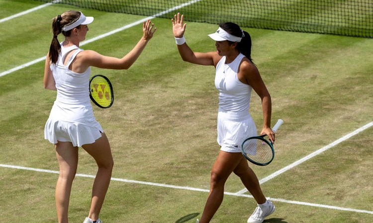 Mika Stojsavljevic and Mimi Xu high fiving on corut at Wimbledon